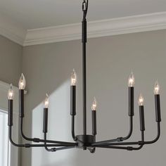 a black chandelier with six candles hanging from it's center and four lights on each side