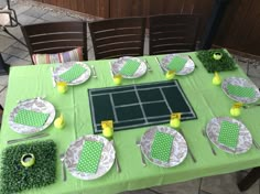 a table set up with tennis themed plates and place settings