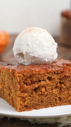 a piece of cake on a white plate with a scoop of ice cream on top