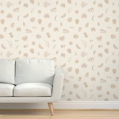 a white couch sitting in front of a wallpapered with different shapes and sizes