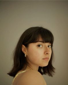 a woman with dark hair is looking at the camera