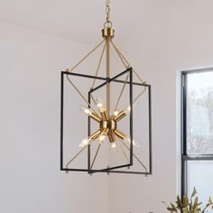 a chandelier hanging from the ceiling in a room with white walls and windows