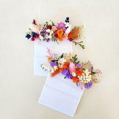 two pieces of paper with flowers on them sitting next to each other in front of a white background