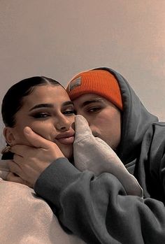 two people are hugging each other on the bed with one person wearing an orange headband