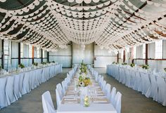 a banquet hall with tables and chairs covered in white tablecloths