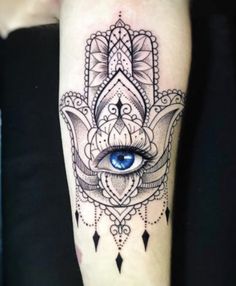 a hamsa tattoo on the arm with an eye and diamond pattern around it's eyes