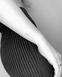 a woman's arm with a small tattoo on the left side of her body