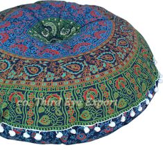 a colorful round pillow with pom poms on the bottom and an intricate design