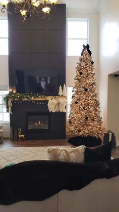 a living room with a christmas tree in the corner and a fire place next to it