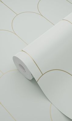 a white and gold wallpaper with circles on the bottom, along with a roll of tape