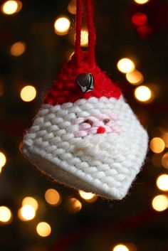 a crocheted ornament hanging from a christmas tree with lights in the background