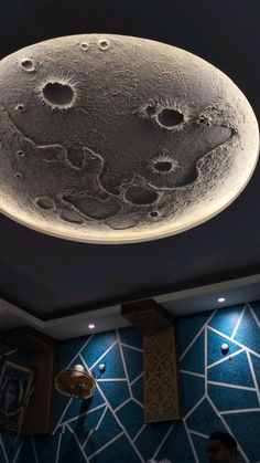 the ceiling light in this restaurant is made out of metal and has an image of the moon on it