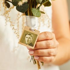 a woman holding a bouquet of flowers and a small card with an image of a man