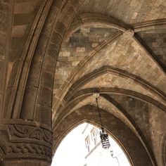 an arch in the middle of a building with a light hanging from it's ceiling