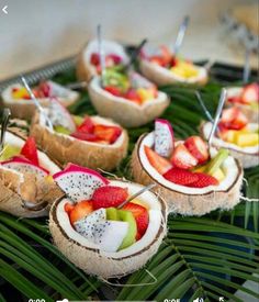 some fruit is cut in half and placed on top of the palm fronds