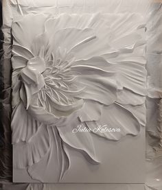 a large white flower on top of a piece of paper