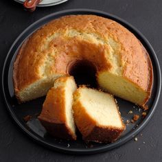 a bundt cake on a black plate with slices cut out and ready to be eaten