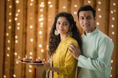 a man and woman standing next to each other holding a plate with food on it