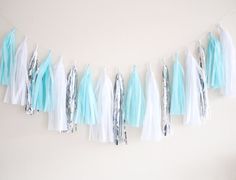 tissue tassels and streamers are hanging from the wall in front of a white wall