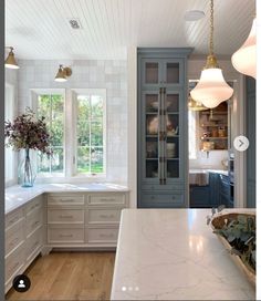 a kitchen with marble counter tops and white cabinets