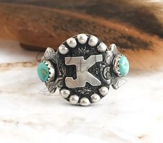 To order: Select your size Add either your initial in the personalize box or the word brand Place your order. Send your photo of your brand to me at pintodysilver@gmail.com This western Initial ring features 2 blue Kingman turquoise stone. Your Letter or brand can be featured in the center of this ring. Something unique that is only yours hand crafted from sterling silver. A big ring feel without the bulk this one is sure to be your go to ring for every day. Want your brand on this ring? We can Western Promise Rings, Custom Class Rings, Western Ring, Western Rings, Western Fits, Class Rings, Cattle Brands, Cowgirl Bling, Bracelet Size Chart