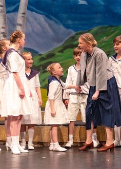 a group of children standing next to each other on a stage