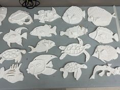 several white clay cutouts of fish and turtles