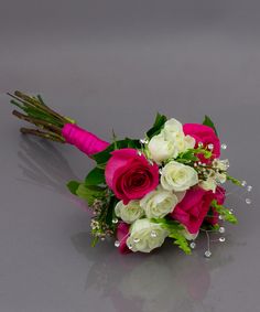 a bridal bouquet with pink and white flowers on a grey surface, close up