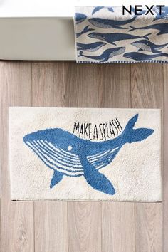 a bathroom rug with a blue whale on it and the words make a splash printed on it