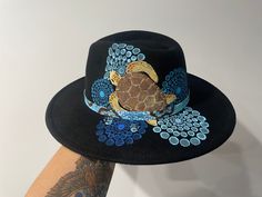 Fedora hat in black   colour adults unisex one size fits most . sea turtle hat   design hand painted by Gomerio Artist Jessica Payne. On country in Coonabarabran NSW . each  design has a beautiful story or connection . Which is sent out with the hat. many designs of custom painted available , artwork just talk with artist Hand Painted Hats Design, Black Wide Brim Hat As A Gift, Black Wide Brim Hat As Gift, Black Artistic Hat With Short Brim, Artistic Black Hat With Short Brim, Artistic Black Adjustable Hat, Adjustable Black Artistic Hat, Black Adjustable Artistic Hat, Artistic Adjustable Black Hat