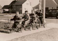 an old black and white photo of children on tricycles