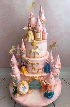 a pink cake with princess figures on it