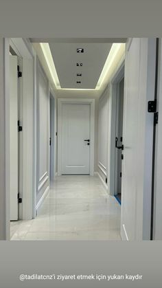 an empty hallway with white walls and doors