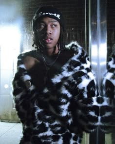 a woman in a black and white fur coat standing next to a mirror with her mouth open