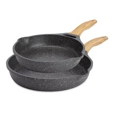 three cast iron skillets with wooden handles on a white background, one is black and the other is gray