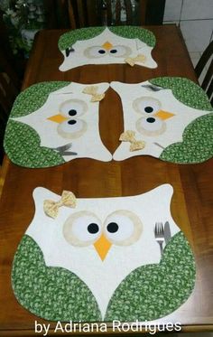 three owl placemats sitting on top of a wooden dining room table with forks and knives