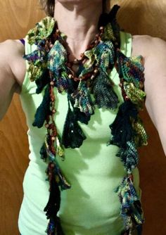 a woman wearing a green tank top and a multicolored crocheted scarf