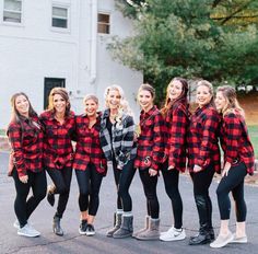 a group of women in red and black flannel shirts posing for the camera