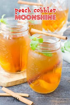 three mason jars filled with iced tea on top of a wooden board next to cinnamon sticks