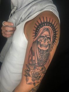 a woman with a skull and rose tattoo on her arm