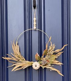 a blue door with a wreath hanging from it's side and flowers on the front