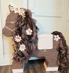 a horse made out of brown paper with flowers on it