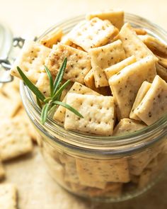 a glass jar filled with crackers on top of a table