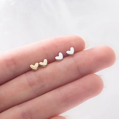 Tiny yet mighty, these heart stud earrings pack a stylish punch. Crafted from high-polish sterling silver or silver-plated base metal, these miniature hearts are a chic way to show your love. At just 4 mm wide, they're barely there yet make a big statement. Slip them on for a quick hit of romance any day of the week. Their petite size and minimalist design allow them to pair with everything in your closet, from casual tees to evening gowns. Wear them solo or stack with other studs - either way, they'll infuse your look with a touch of sweet sentiment. Add them to your cart now and fall for these darling heart earrings. Materials: 925 sterling silverFinish: platinum plate, gold plateDimensions: 0.18 x 0.13 in Jewelry Care: See more information about how to care for your jewelry here. Shippi Trendy Sterling Silver Cartilage Earrings As A Gift, Trendy Tiny Sterling Silver Earrings, Minimalist Hypoallergenic Double Heart Jewelry, Minimalist Heart Shaped Cartilage Earrings As Gift, Minimalist Heart-shaped Cartilage Earrings As Gift, Tiny Minimalist Heart Earrings, Minimalist Everyday Heart Cartilage Earrings, Minimalist White Cartilage Earrings For Anniversary, Trendy Sterling Silver Heart Earrings For Everyday