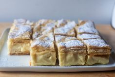 several pieces of cake on a plate with powdered sugar toppings and icing