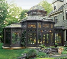 a gazebo in the middle of a yard next to a house