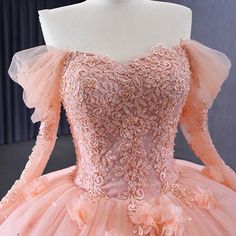 Crafted with a meticulous eye for detail, this stunning peachy-pink quinceañera party dress beguiles with its delicate fit lace bodice sprinkled with tiny pearls, its sumptuous tulle puff sleeves, and its graceful back-peplum trimmed with a satin ribbon lacery for an adjustable fit. Exquisite tuffs of 3D flowers are lovingly hand-sewn throughout, completing a look fit for a fairy-tale. material: organza color: as shown type: party ball gown sweetheart neckline lace up back sweep train shown as s Pink Lace Quinceanera Dress With Sweetheart Neckline, Pink Quinceanera Dress With Lace Bodice, Pink Ball Gown Quinceanera Dress With Lace Bodice, Pink Quinceanera Dress With Lace Bodice For Debutante Ball, Quinceanera Dresses Coral, Wedding Guest Dress 2023, Tulle Puff Sleeves, 2023 Ball Gown, Red Quinceanera Dress