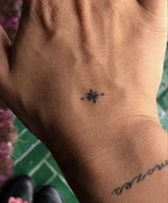 a person's hand with a small tattoo on it