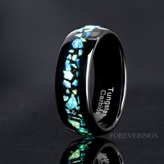 a black ceramic ring with blue and green opalite inlaying the center