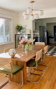 a dining room table with chairs and vases on it